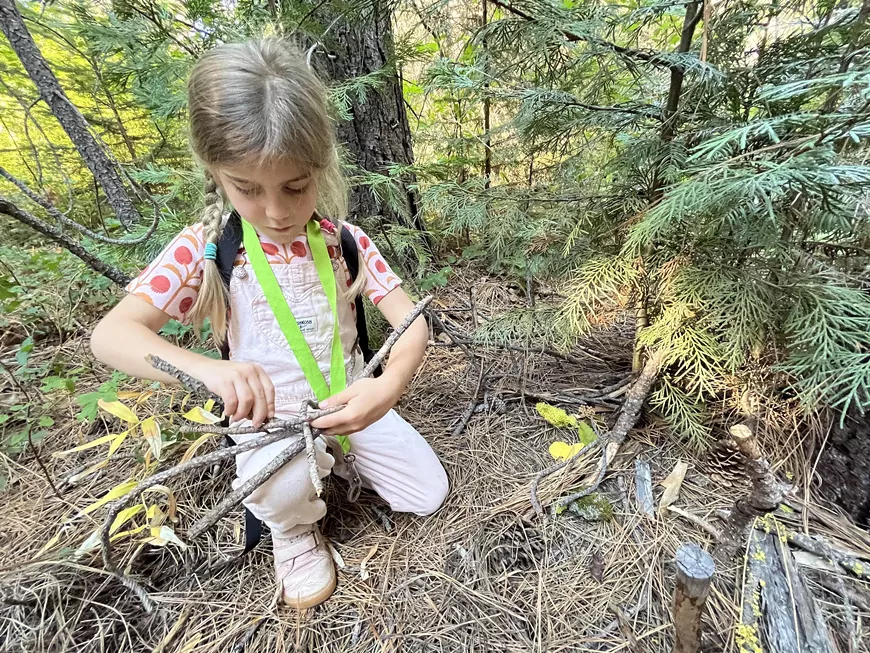 A kiddo builds a fairy house during a Kids Fairy House Walk at Metolius Preserve.