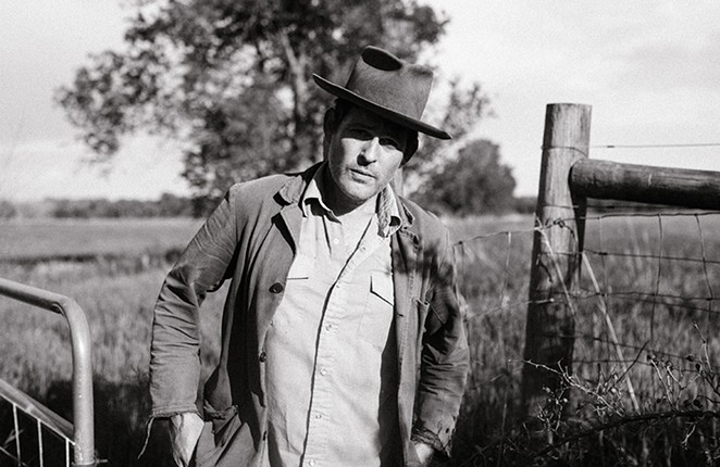 Gregory Alan Isakov in black and white in a farm setting