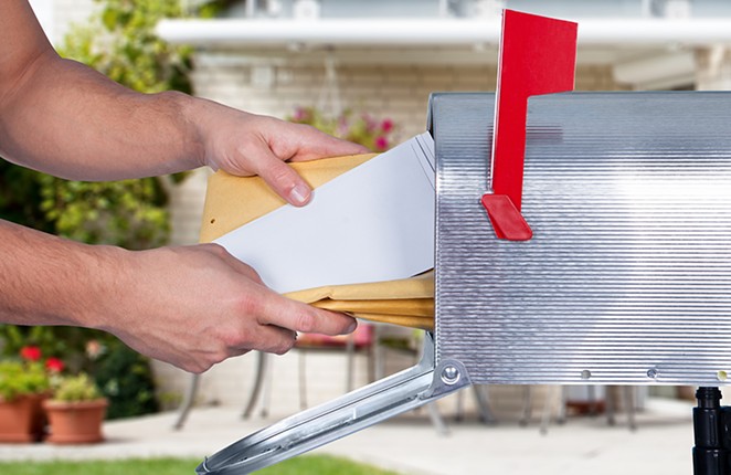 Person pulls mail from mailbox