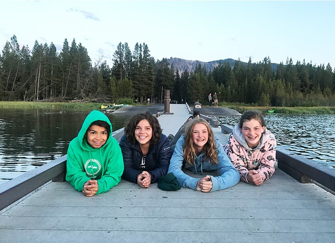 Camp kids smiling happily on a dock